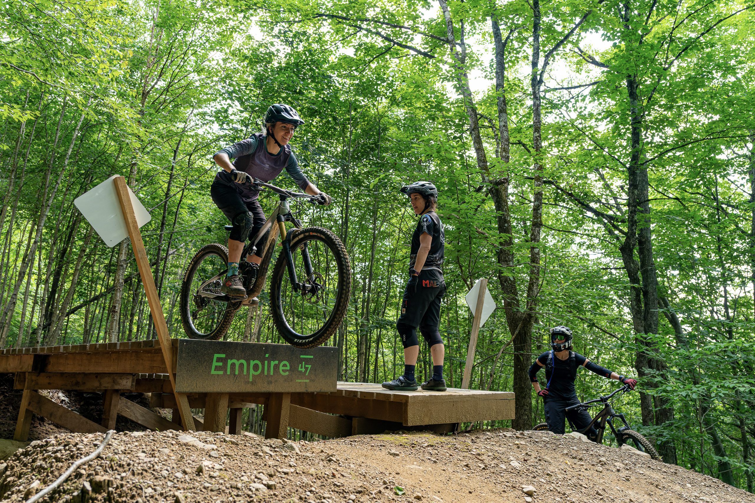 Une personne niveau avancé effectuant une technique de drop en vélo de montagne sur un obstacle d'Empire 47.